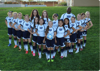 Girls soccer team photo with two coaches on side and 15 fifteen girls in a V-formation wearing QCIFY sponsor on uniform
